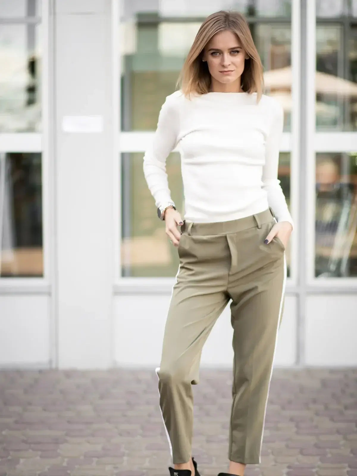 Fashionable woman in comfortable women's pants and a white sweater, showcasing style and ease of wear.