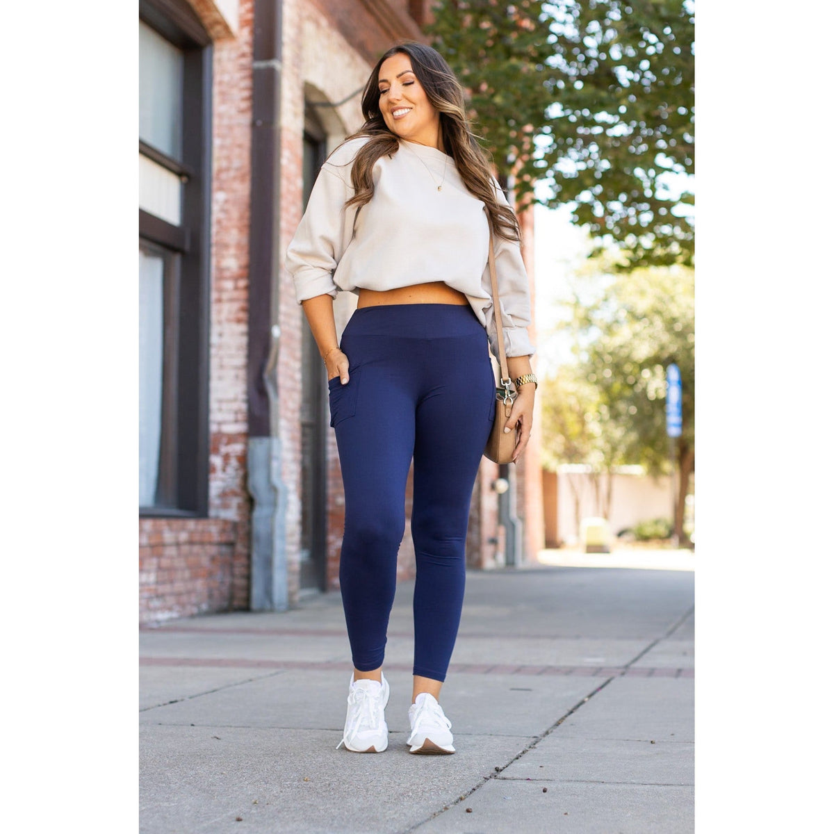 Nyla navy full-length leggings with pockets styled with a casual outfit on a sunny street.