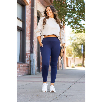 Nyla navy full-length leggings with pockets styled with a casual outfit on a sunny street.