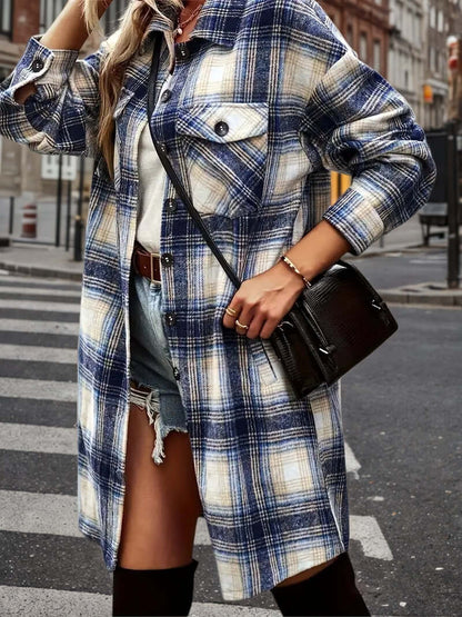 Women's plaid shacket outfit featuring an oversized flannel shirt jacket and distressed denim shorts on a city street.
