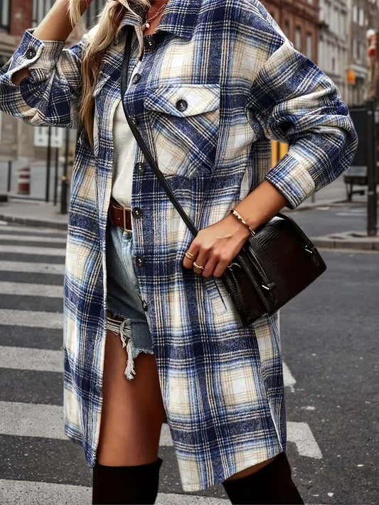 Women's plaid shacket outfit featuring an oversized flannel shirt jacket and distressed denim shorts on a city street.