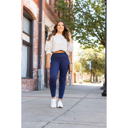 Nyla navy full-length leggings with pockets, styled for comfort and casual outings, paired with a cropped sweater.