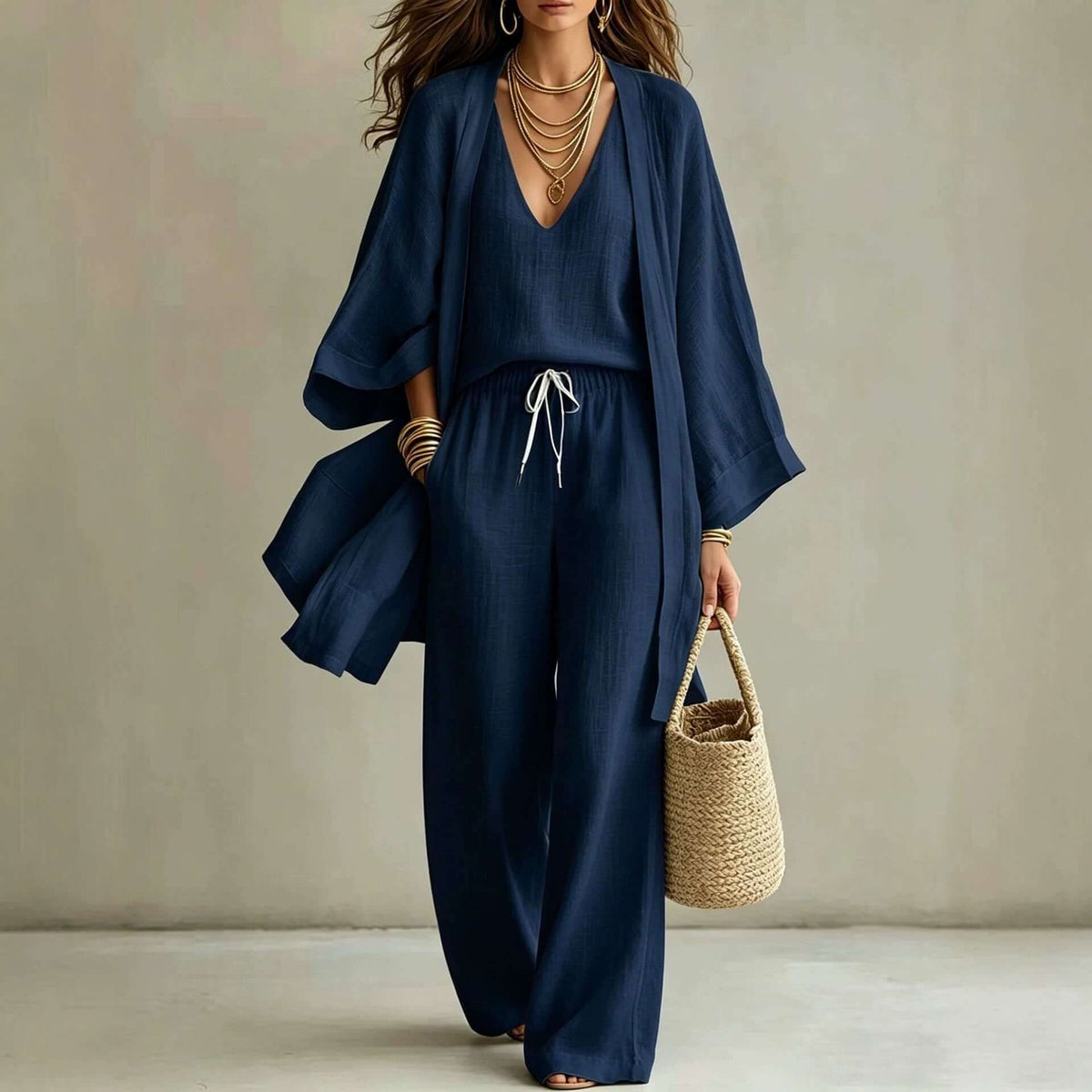 Model wearing a women's 3-piece cardigan set featuring a relaxed cardigan, sleeveless vest, and wide leg pants in navy.
