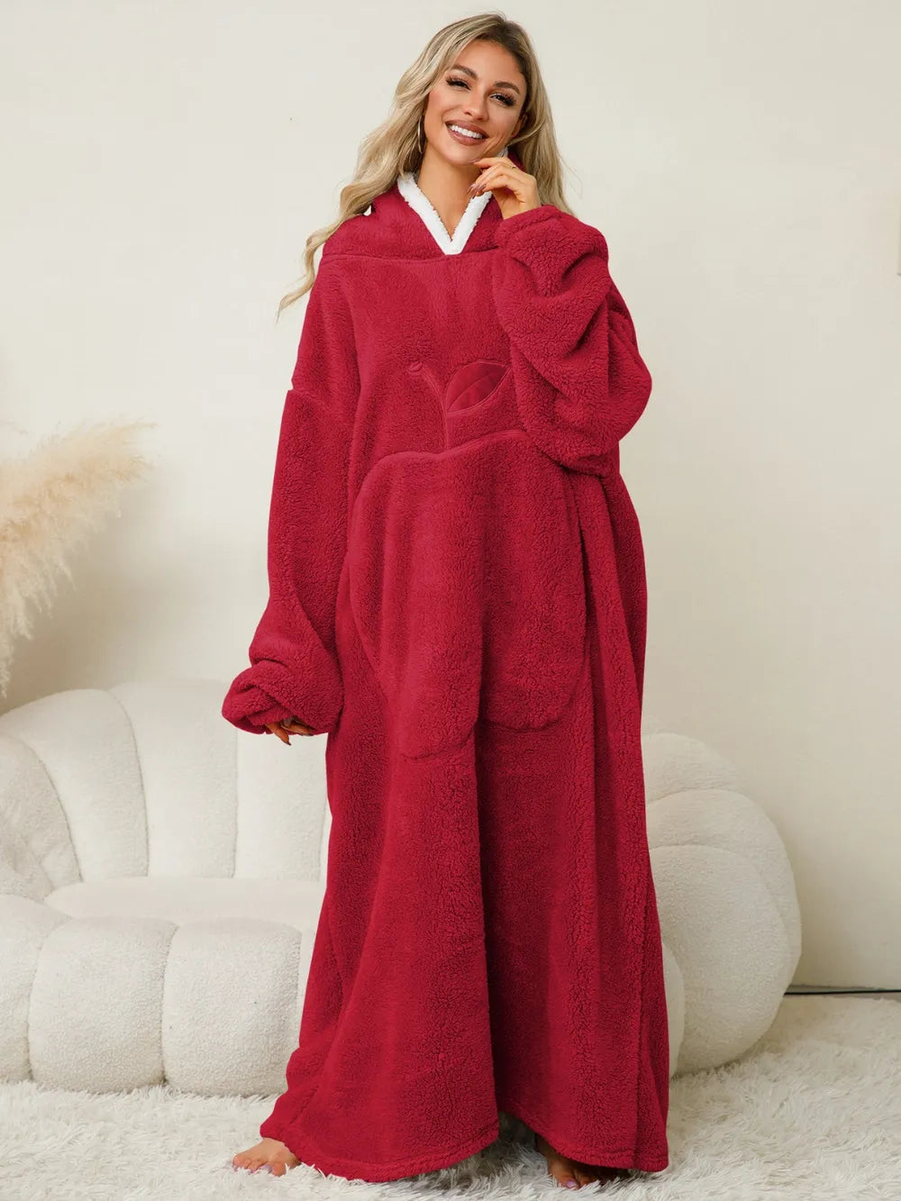 A woman wearing a cozy red women's hooded lounge dress, showcasing the relaxed silhouette and soft fabric.