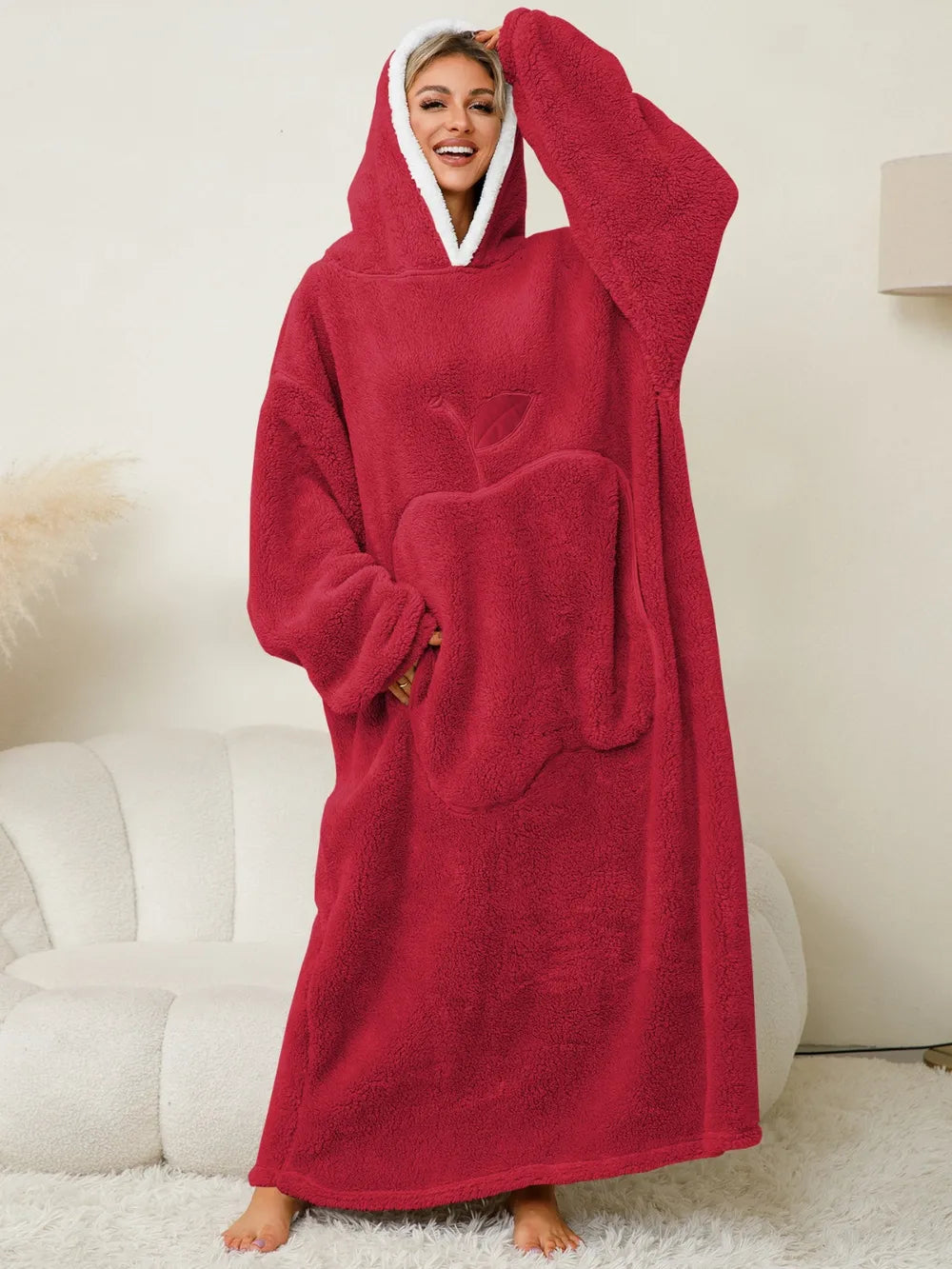 A woman wearing a cozy, red women's hooded lounge dress with a pocket and hood, perfect for relaxation and comfort.