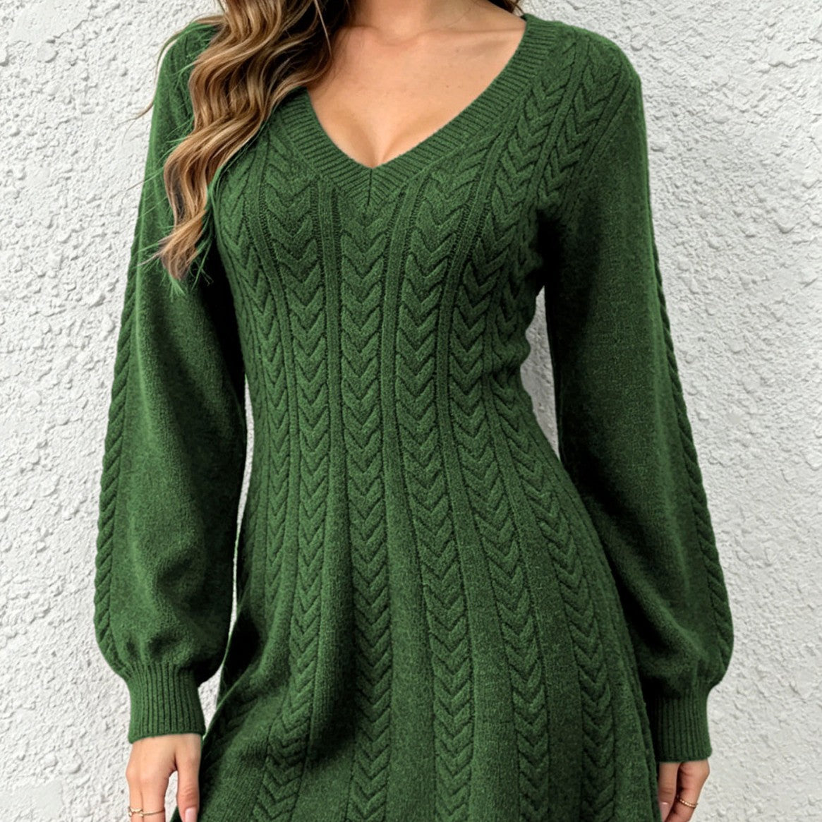 Close-up of the army green cable-knit V-neck pullover dress on a model