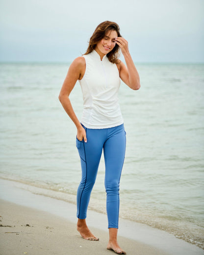 Model wearing high-performance swim leggings on the beach, showcasing comfort and style in outdoor activities.