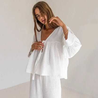 Woman modeling women's cotton v-neck pajama set in white, showcasing comfort and style.