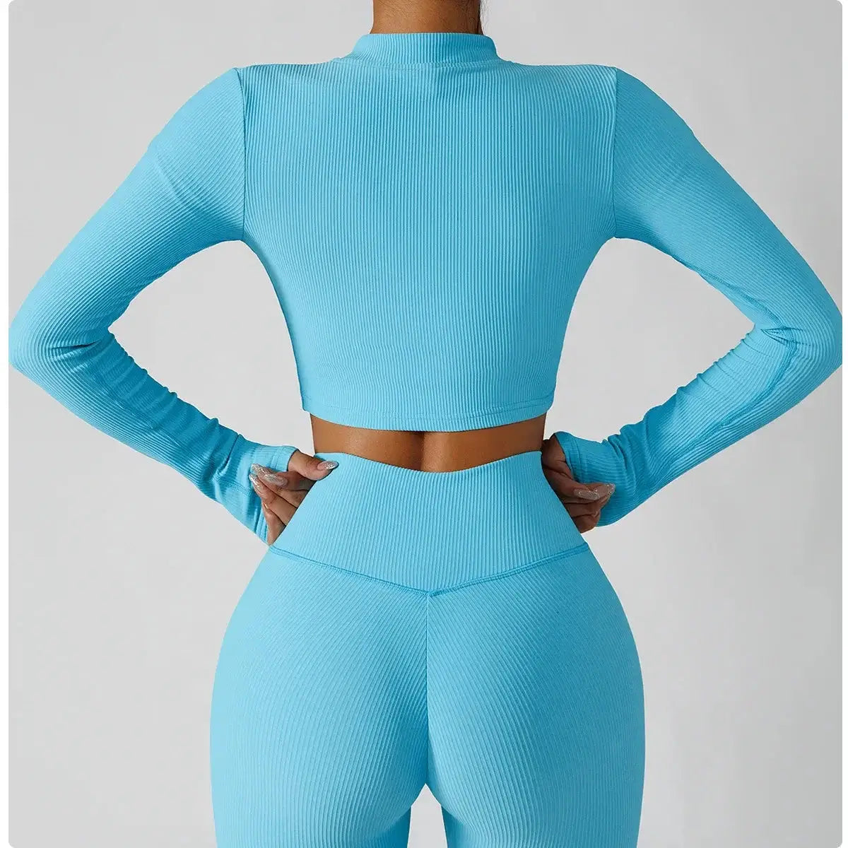 Back view of a model wearing a 3-piece seamless yoga set, featuring a cropped blue jacket and matching leggings.