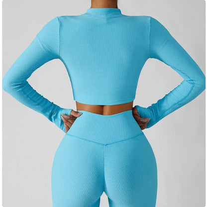 Back view of a model wearing a 3-piece seamless yoga set, featuring a cropped blue jacket and matching leggings.
