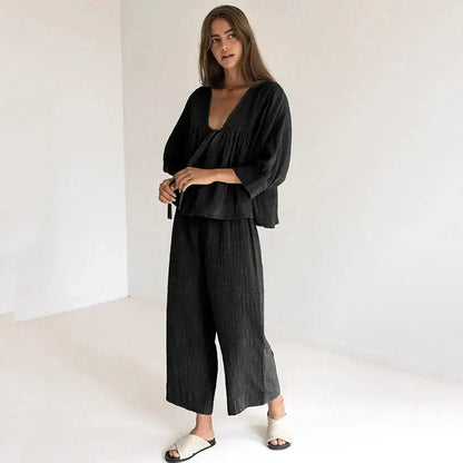 Model wearing women's cotton v-neck pajama set, showcasing comfort and style in a relaxed setting.