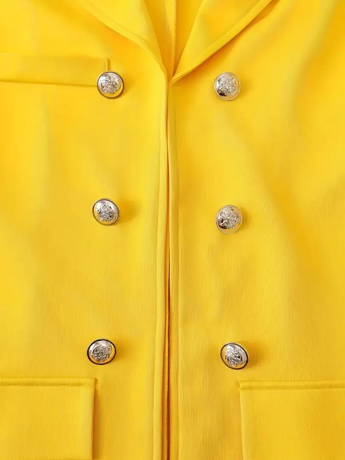 Front view of a vibrant yellow women's jacket featuring silver buttons, part of a womens printed pants suit.