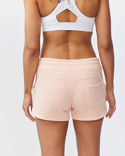 Woman wearing Freasy Garment-Washed Cotton Shorts in soft pink, showing back view with rib-knit waistband.
